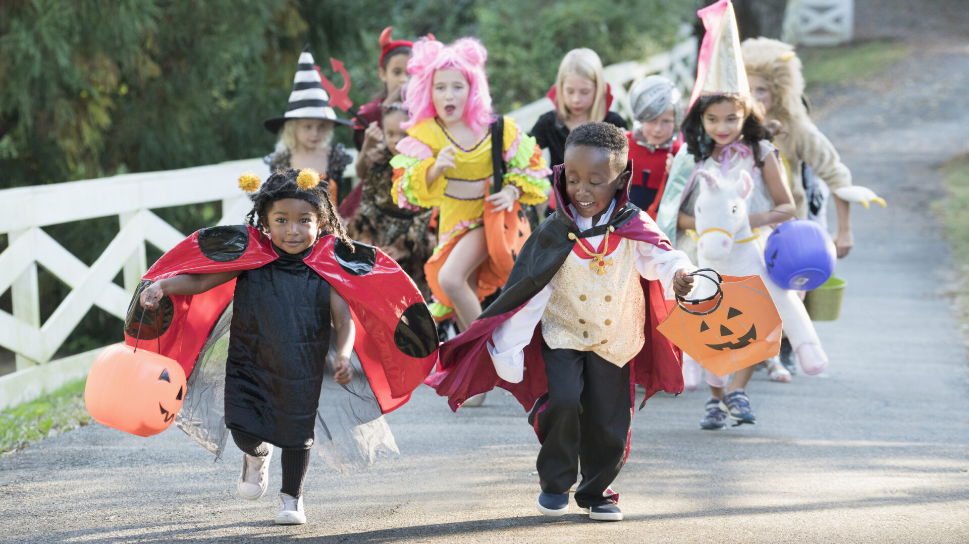 Picture of kids running down the street in Halloween costumes.