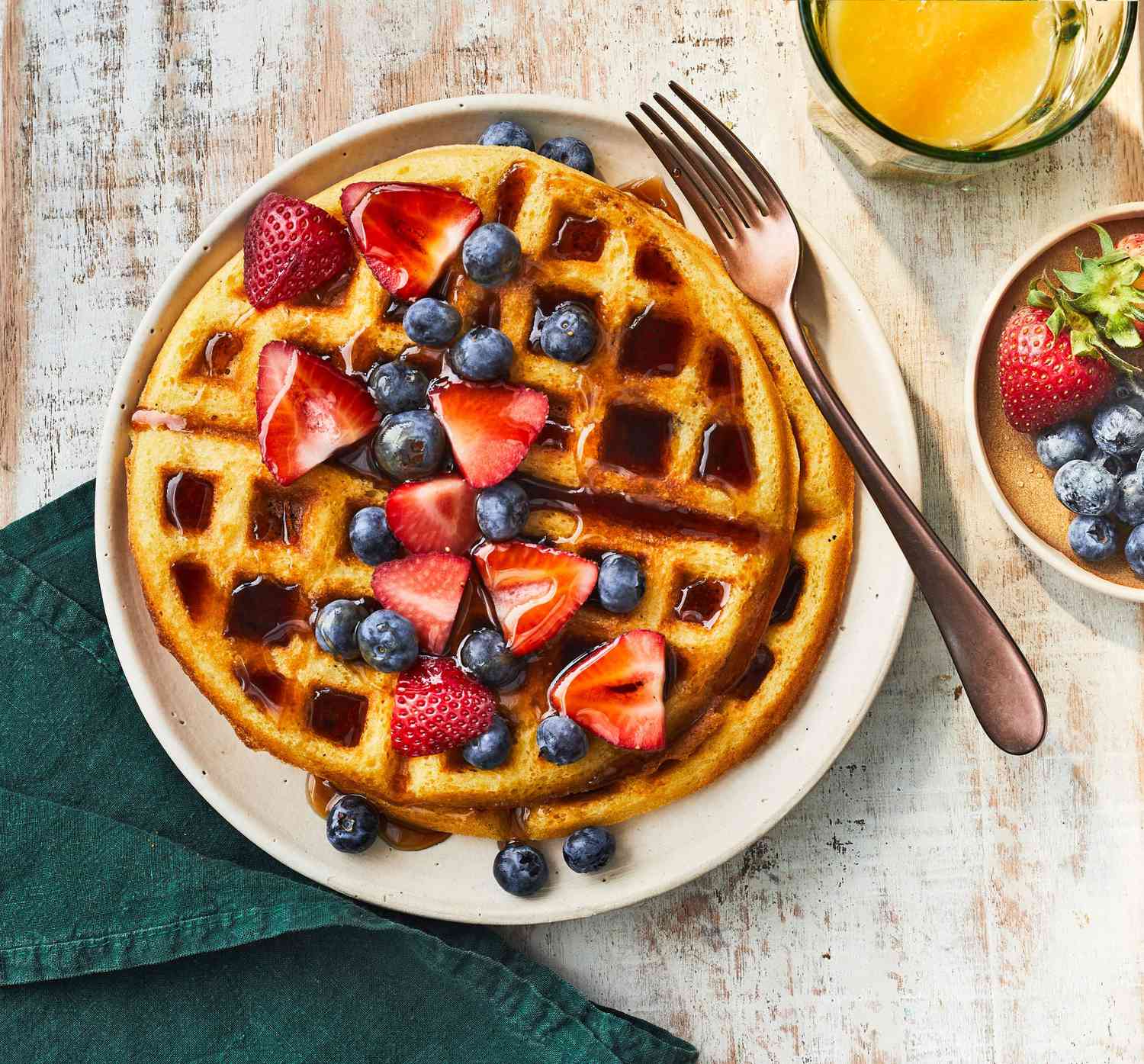 Picture of waffles with strawberries and blueberries on top.