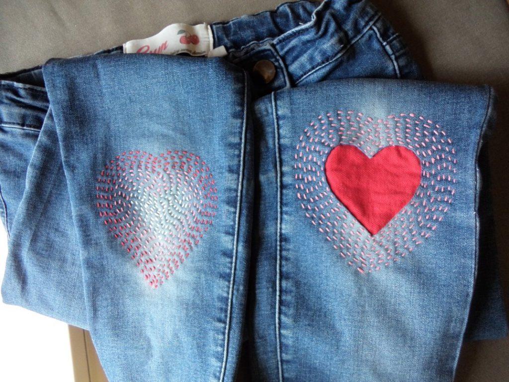 Pair of jeans with sewn on heart patches.